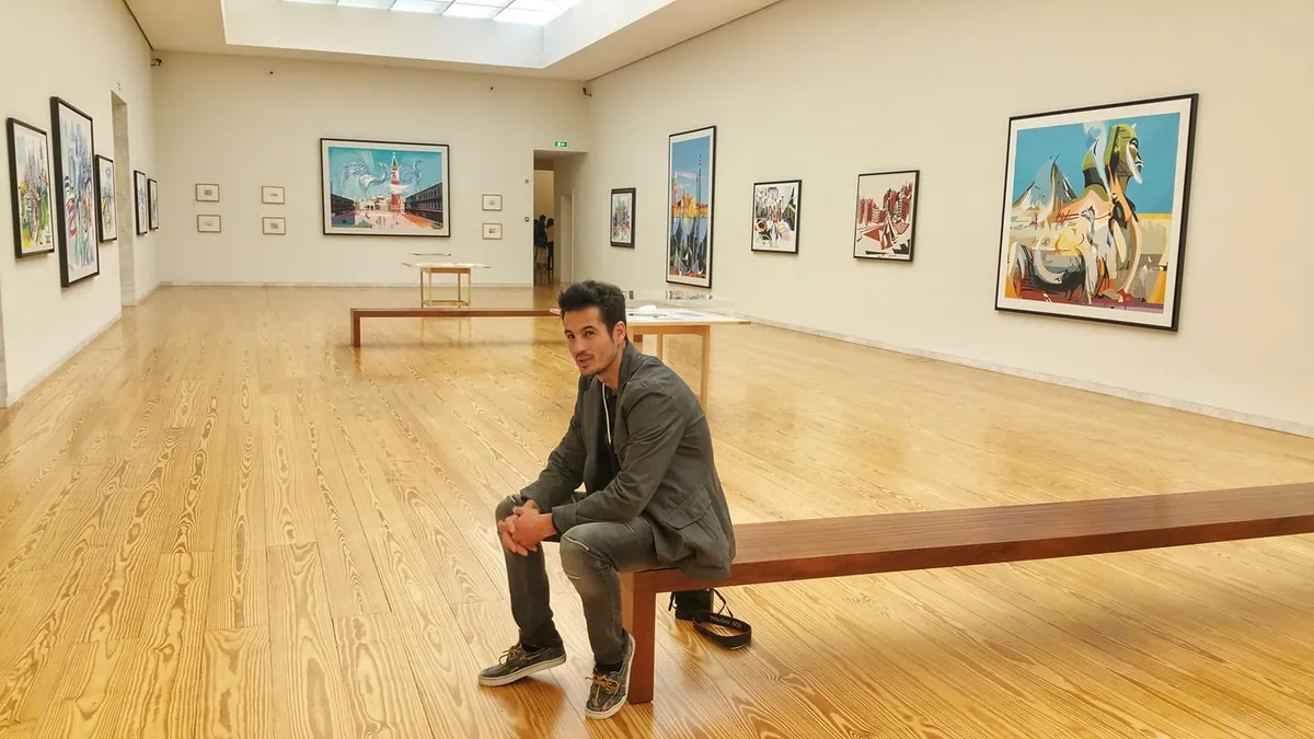 Nuno Duque sentado numa sala de museu com pinturas nas paredes