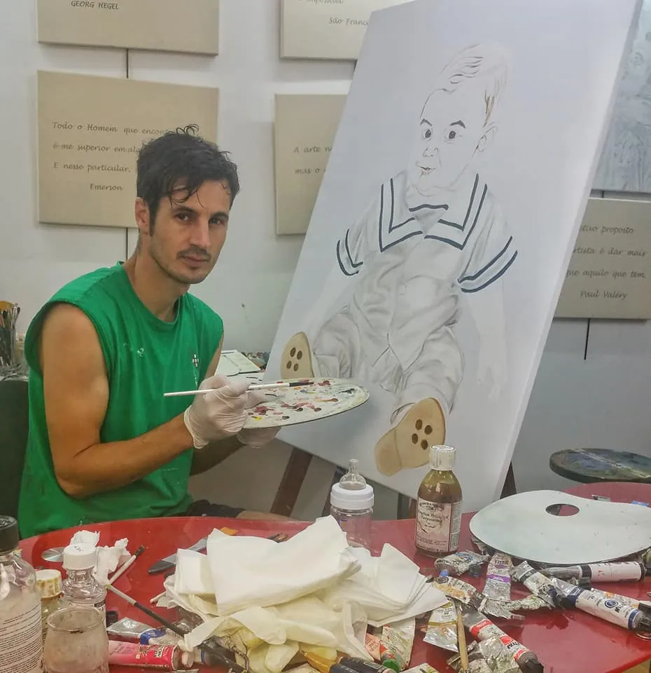 Nuno Duque a pintar no atelier, entre tubos de tinta e uma tela por acabar