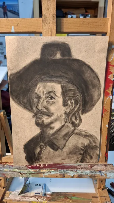Retrato a carvão de um homem de chapéu, terminado no cavalete