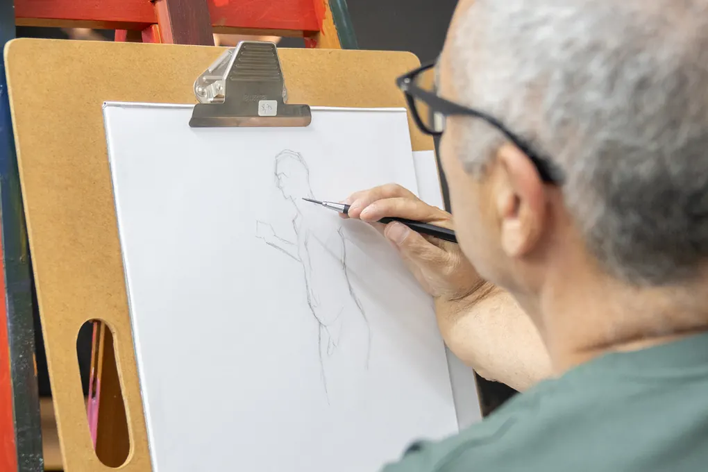 Participante a desenhar a figura humana ao cavalete
