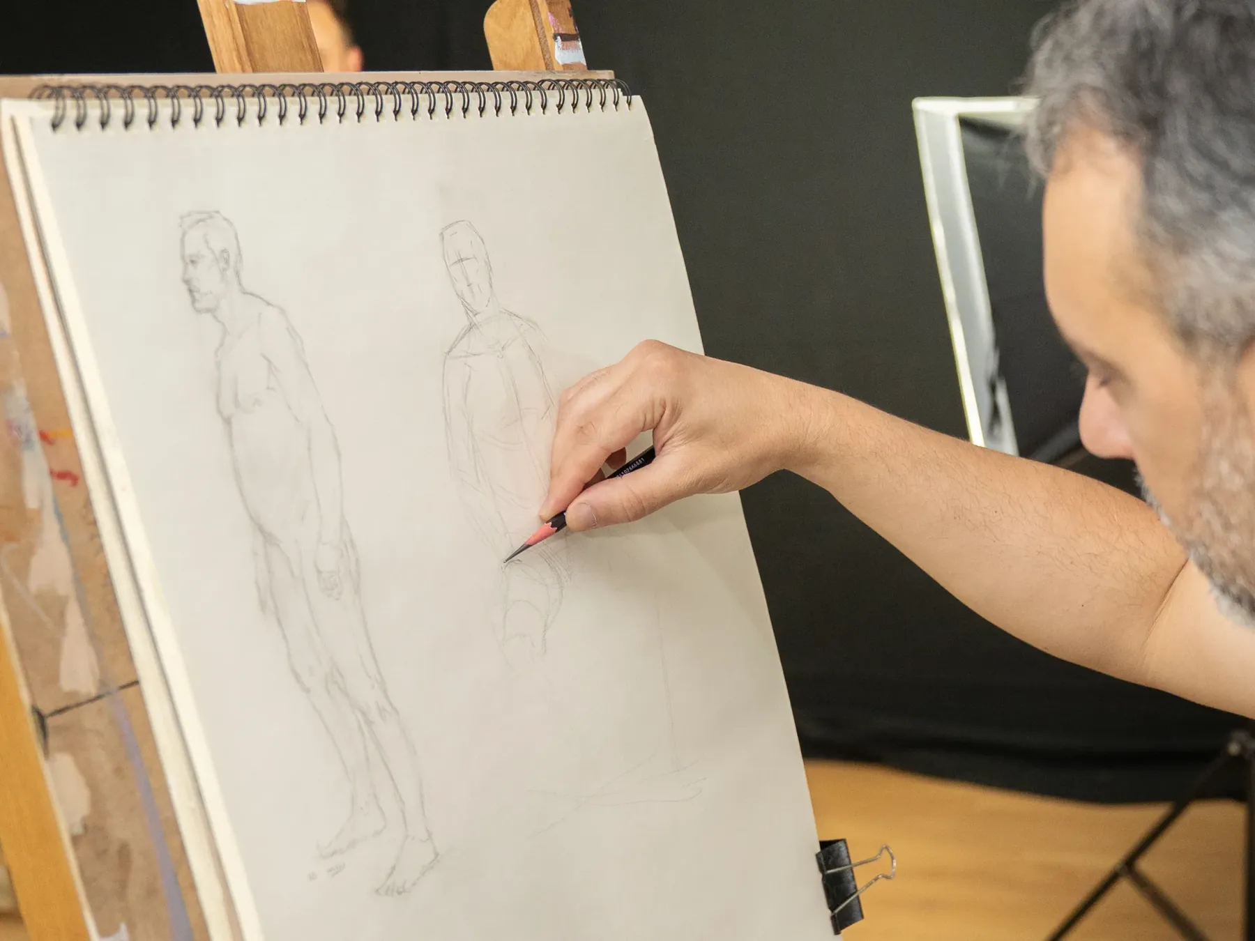 Participante a desenhar a figura humana durante uma sessão de modelo ao vivo no atelier Conceito de Arte